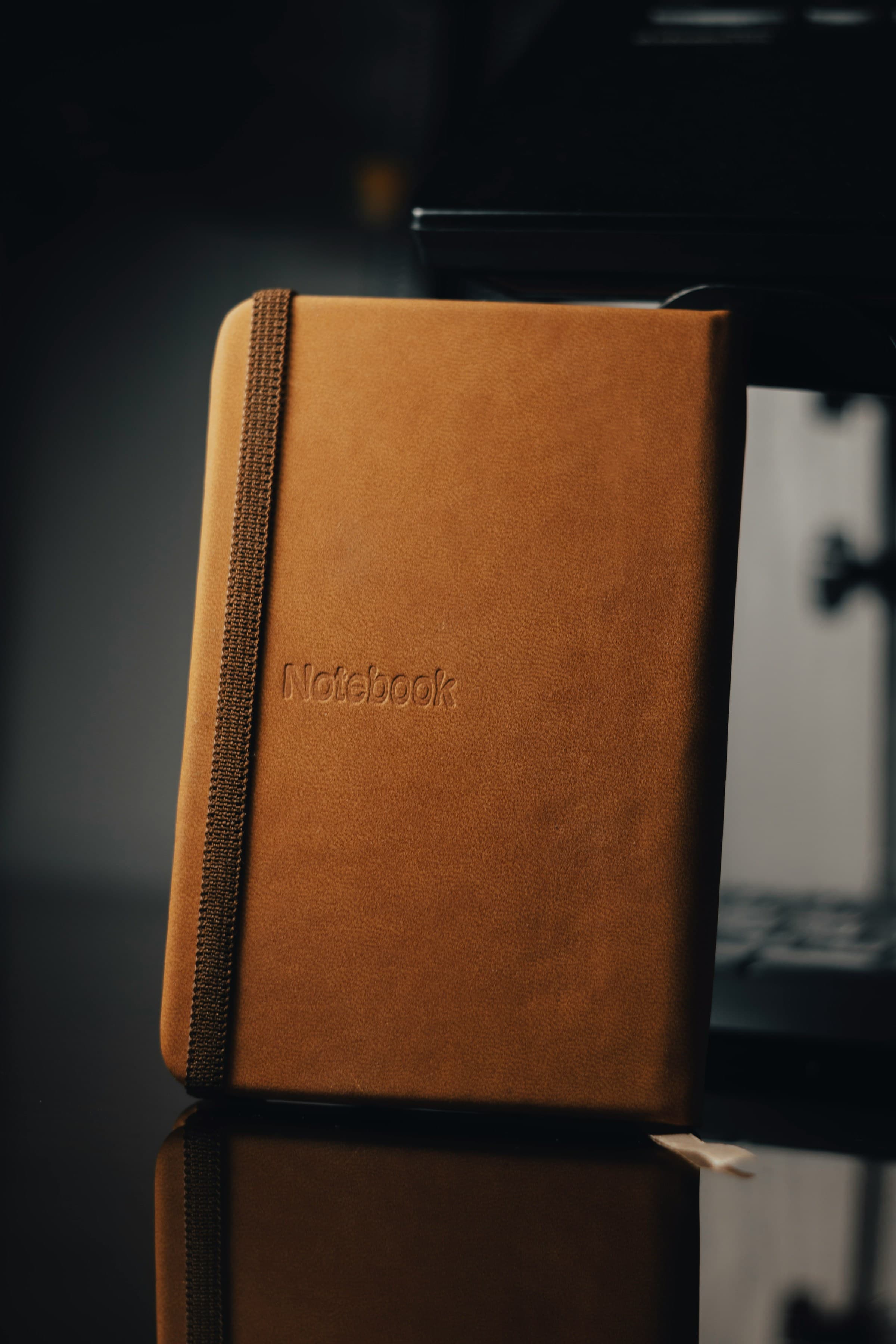 Brown leather notebook resting on a white surface